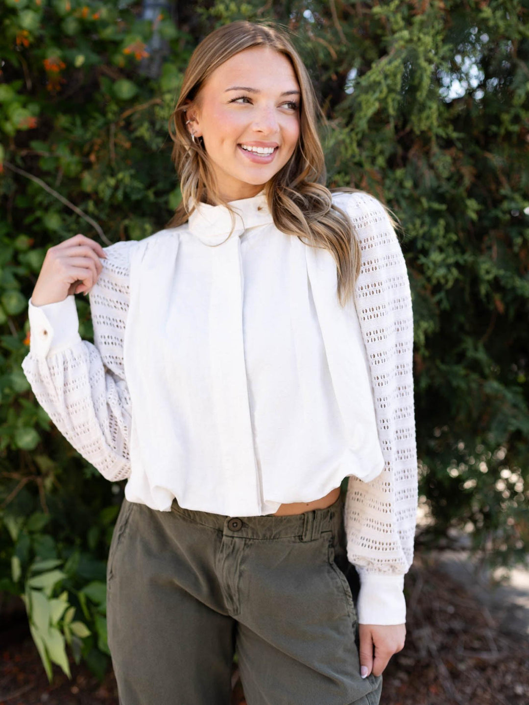 Off White Mystree Bubble Hem Jacket with crochet knit sleeves and button front, worn by a smiling model.