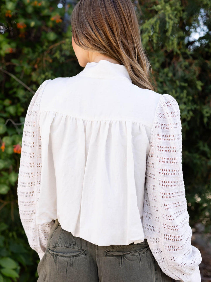 Off White Mystree Bubble Hem Jacket with crochet knit sleeves and gathered back, worn over olive pants.