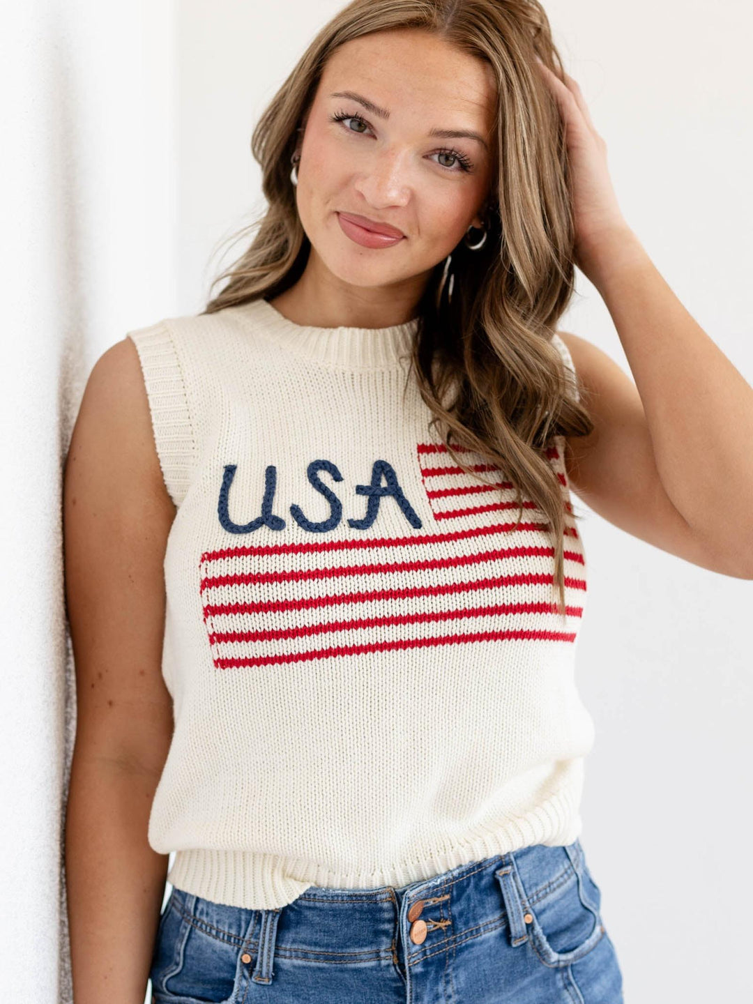 Woman wearing a sleeveless sweater with &