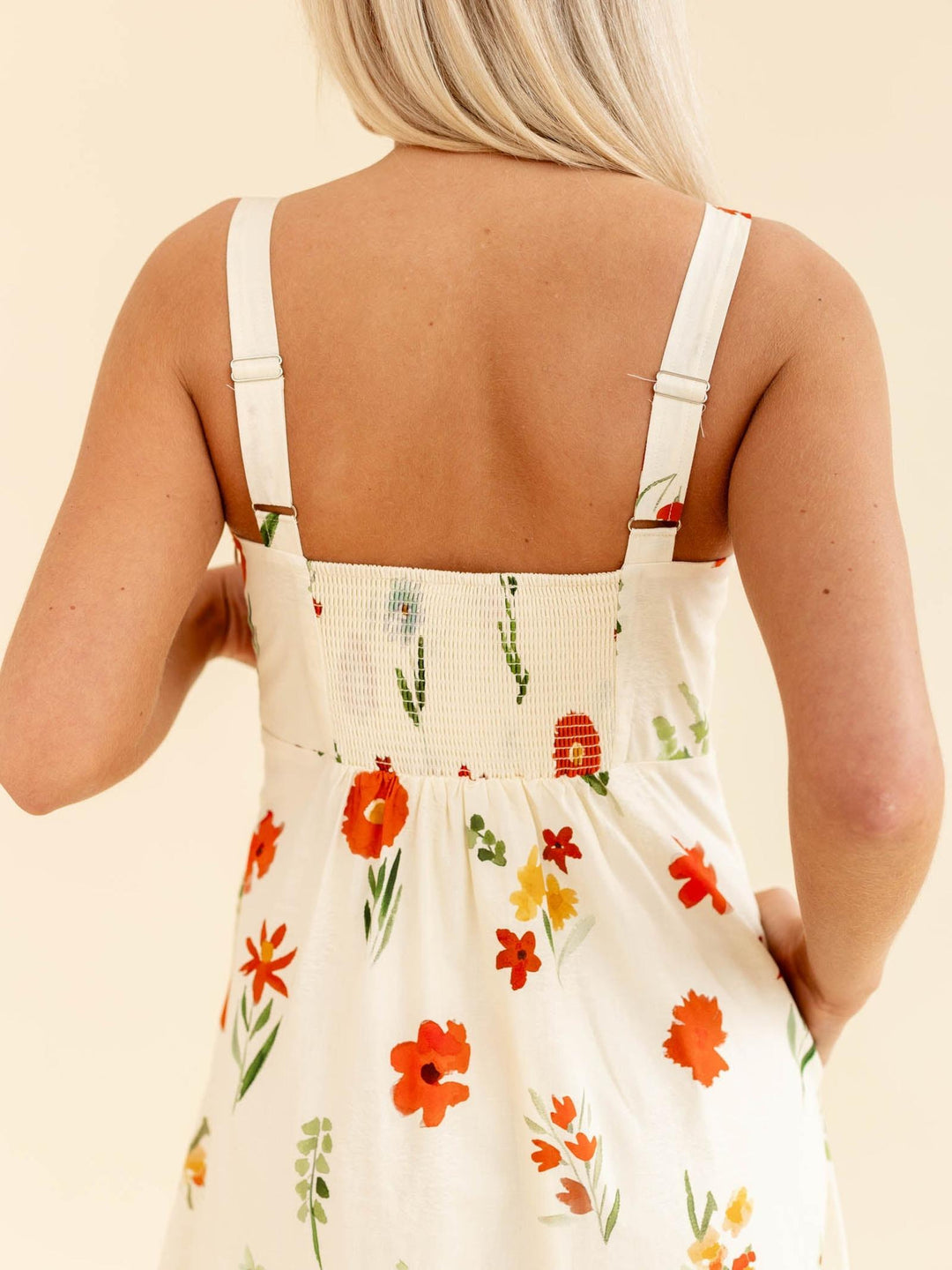Person wearing a floral dress with a beige background