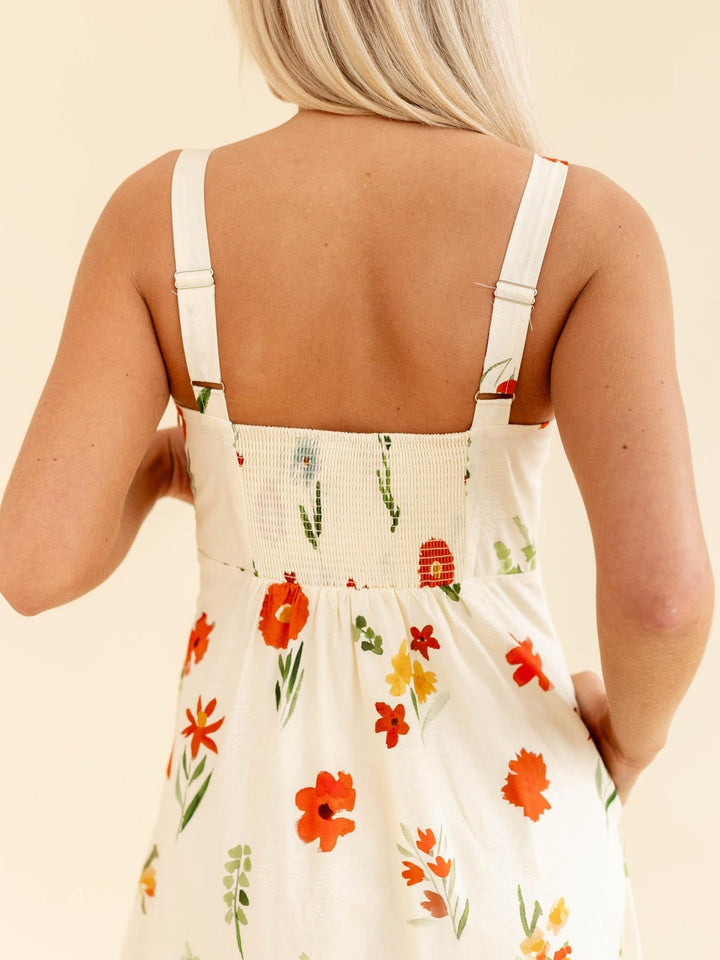 Person wearing a floral dress with a beige background
