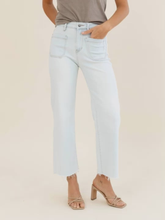 Light blue jeans worn by a person on a beige background