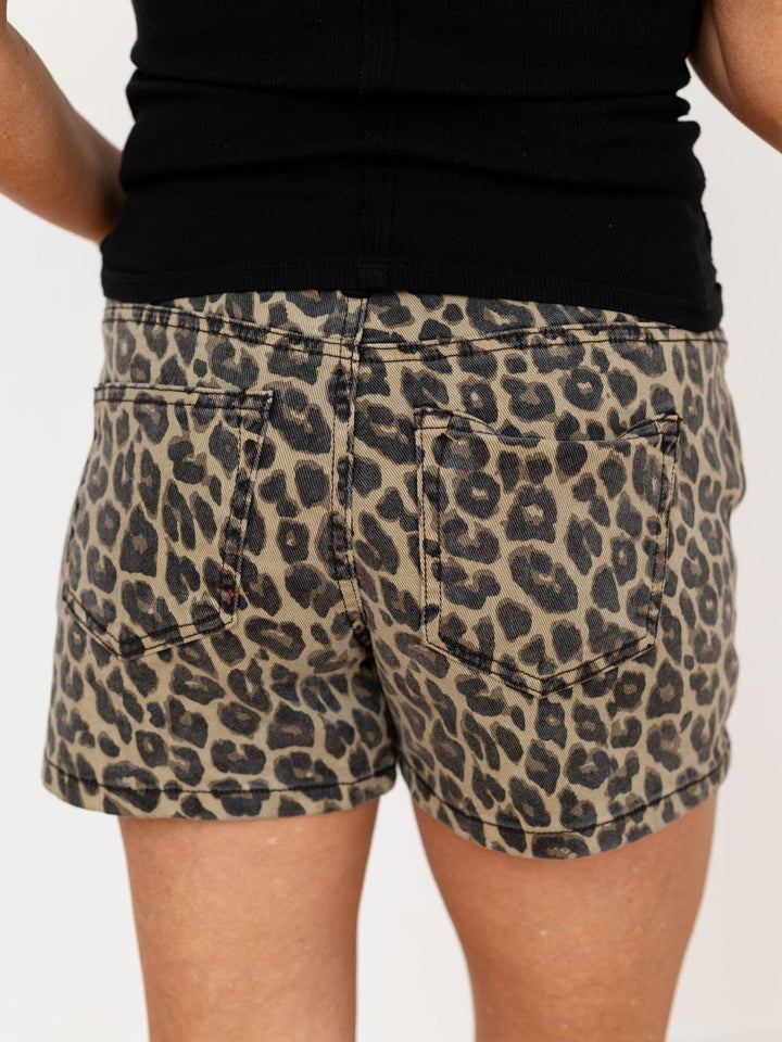 Leopard print shorts worn by a person on a plain background