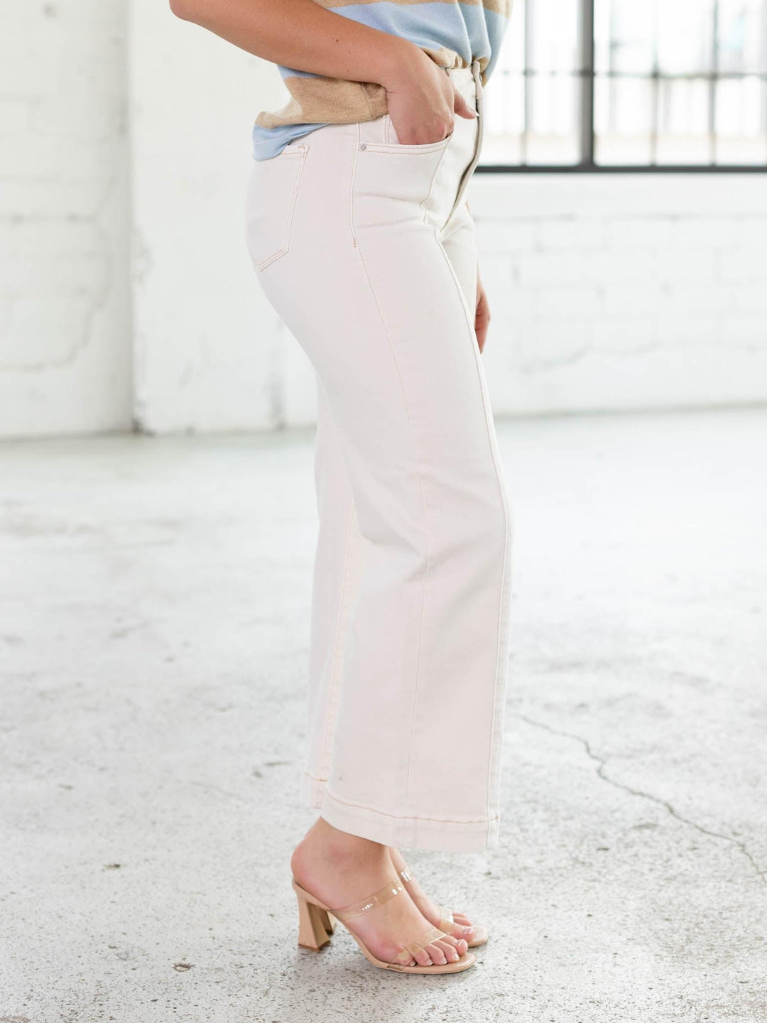 Model wearing RISEN Ivory High Rise Crop Wide Pants with front seam detail and light stitching.