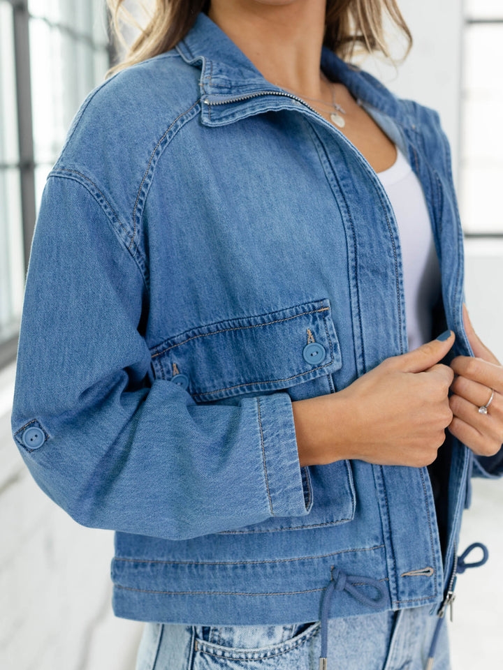 Person wearing a blue denim jacket indoors