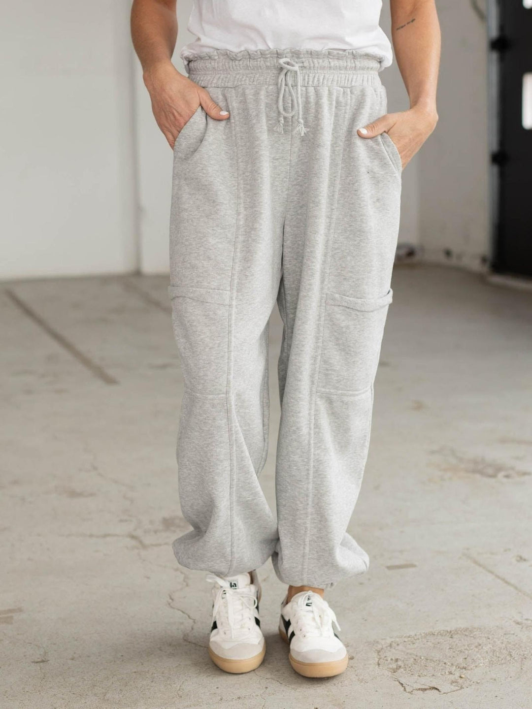 Person wearing light gray sweatpants and white sneakers in an indoor setting