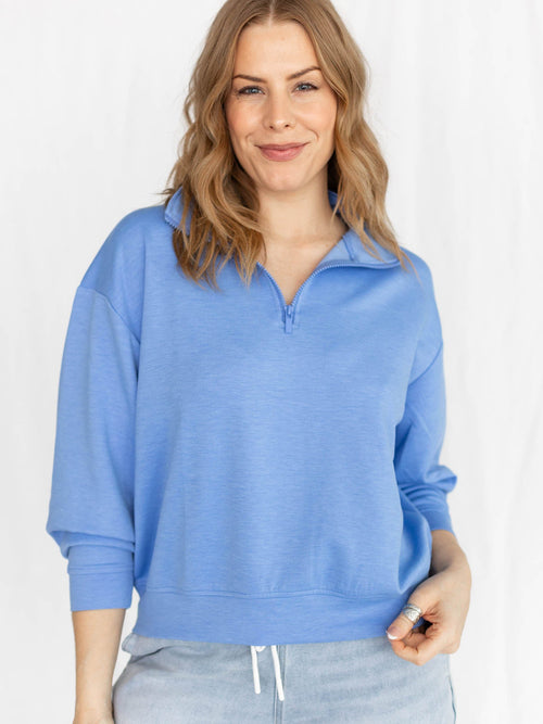 Woman wearing a blue pullover with a white background