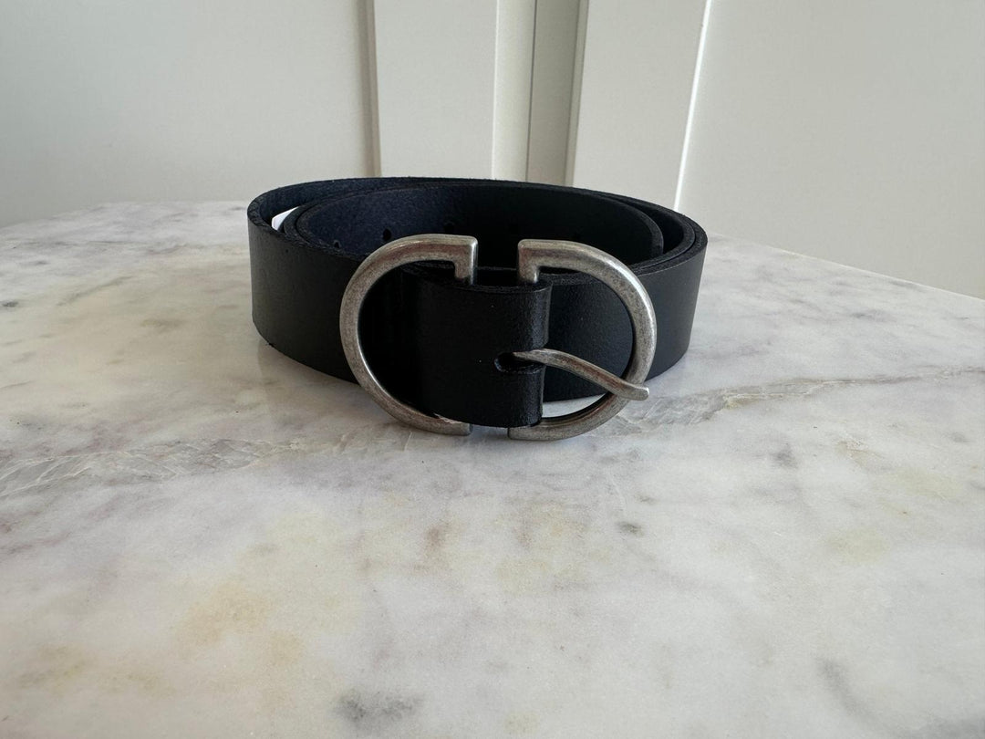 Black belt with silver buckle on a marble surface