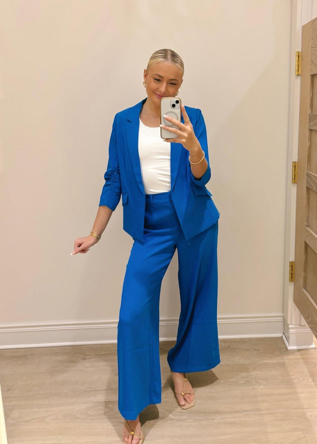 Person wearing a blue suit taking a mirror selfie.