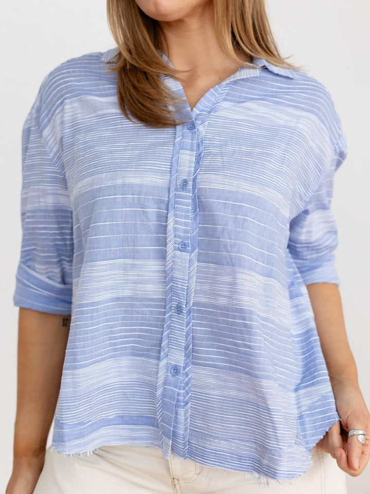 Woman wearing a blue striped shirt against a white background