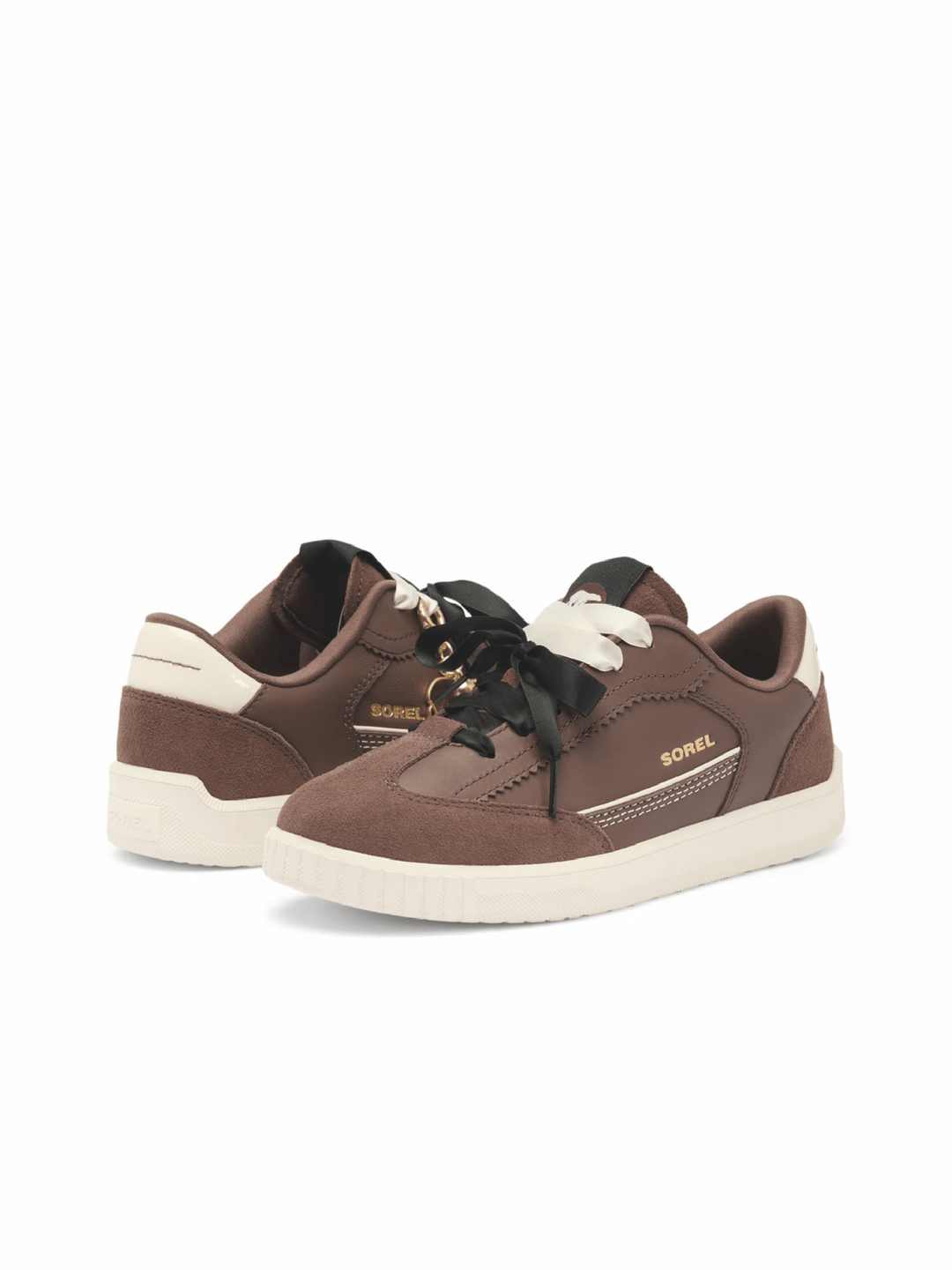 A pair of Sorel brand low-top sneakers in brown suede and leather, featuring black laces with gold accents, off-white soles, and gold branding on a clean white background.