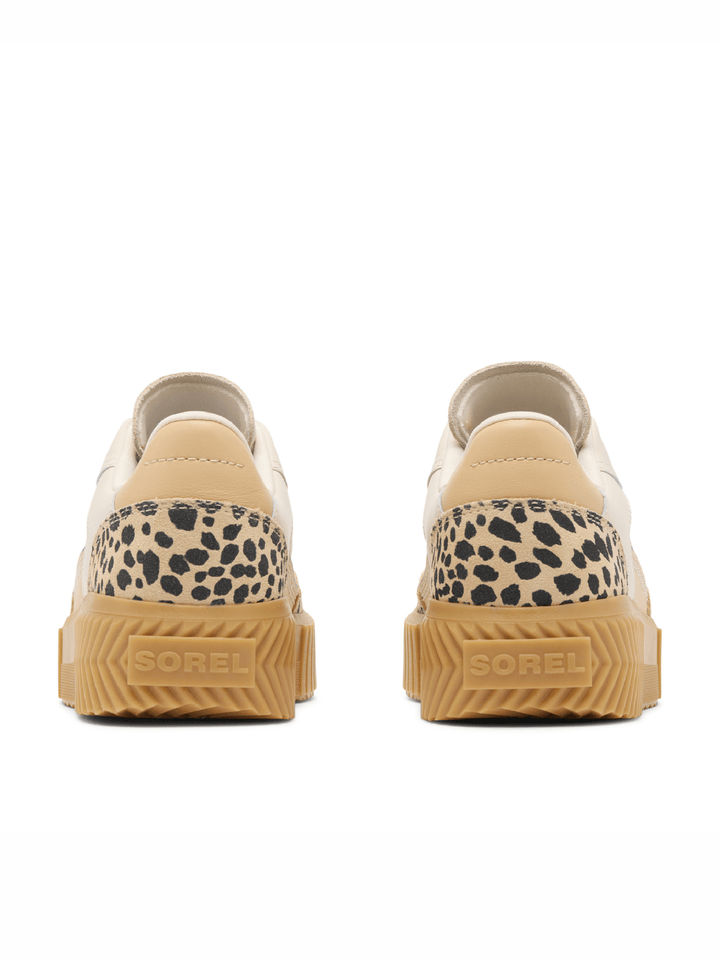 Pair of beige sneakers with leopard print accents on a white background