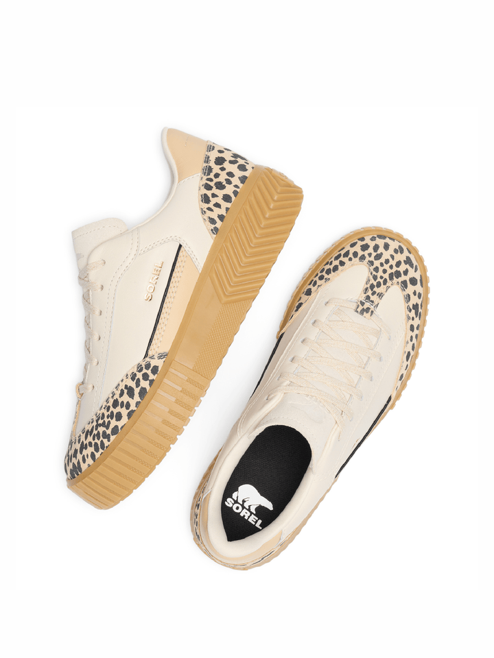 Pair of cream sneakers with leopard print soles on a white background