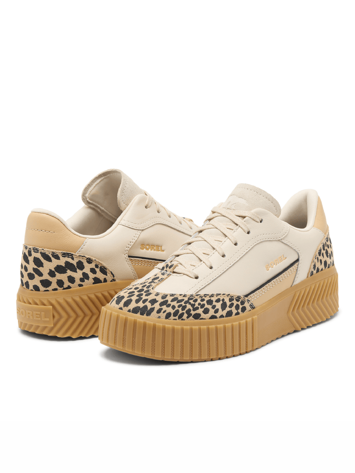 Pair of beige sneakers with leopard print soles on a white background
