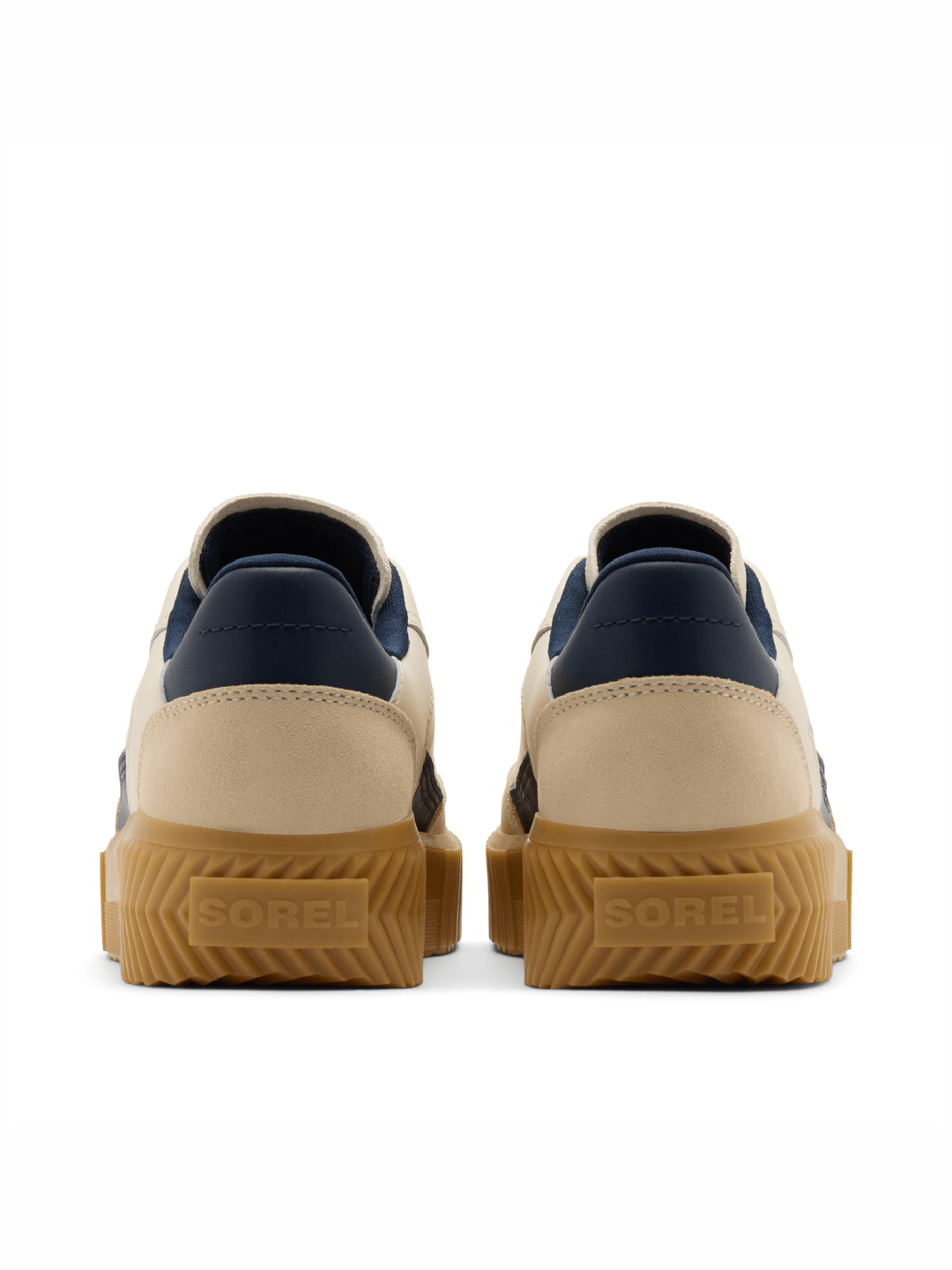 A pair of Sorel sneakers shown from the back, featuring beige and navy blue leather uppers with thick brown gum soles.