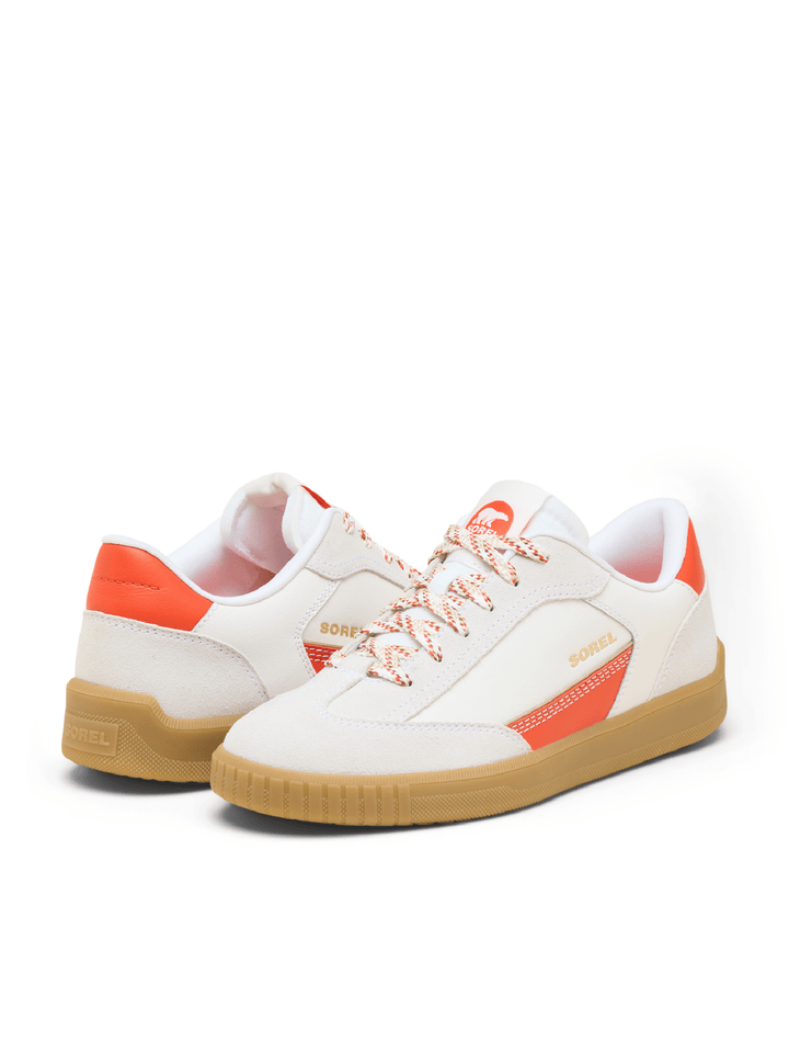 White sneakers with orange accents and brown soles on a white background