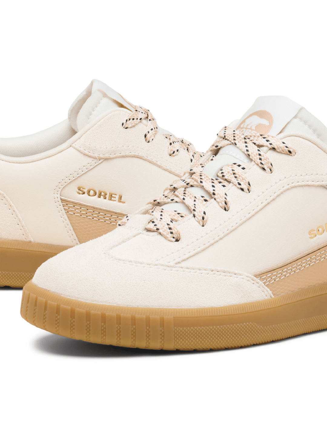 White sneakers with brown soles and visible &