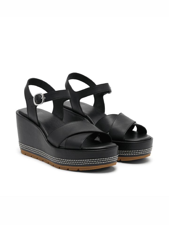 Black wedge sandals on a white background