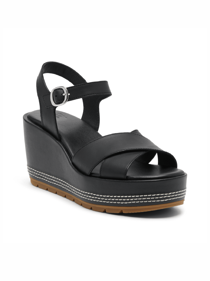 Black wedge sandal with a platform sole on a white background