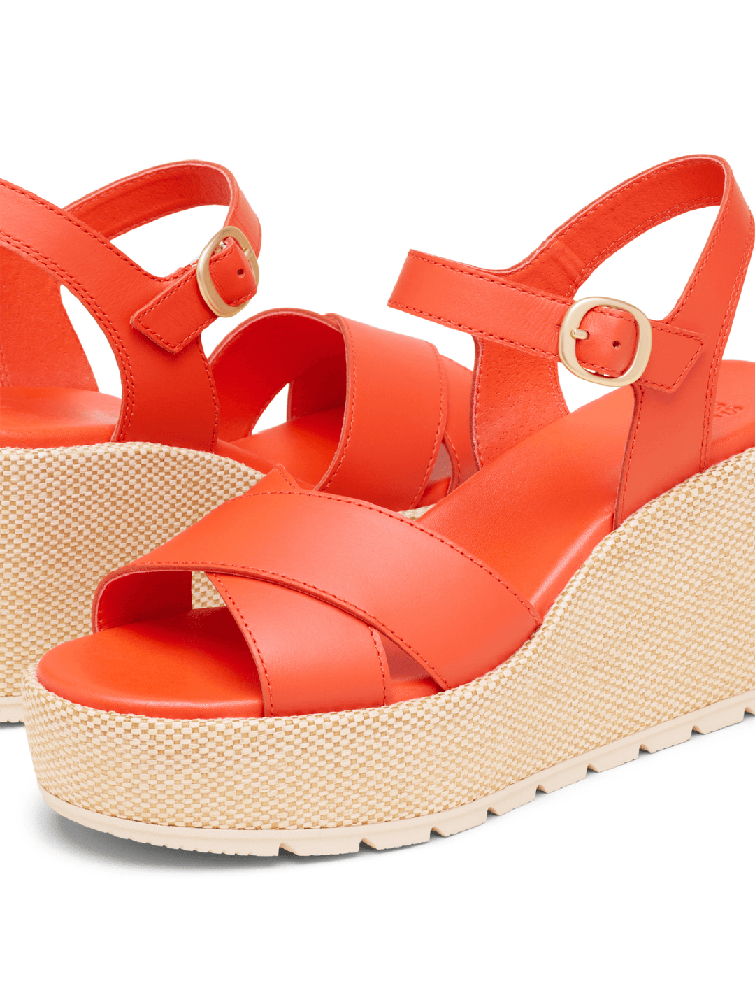 Orange wedge sandals with woven sole on a white background