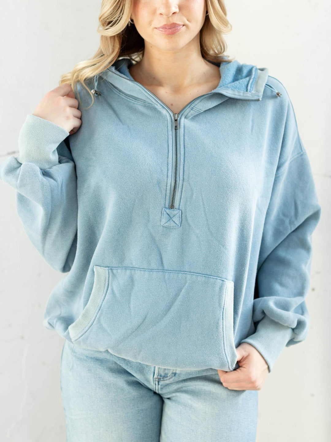 Light blue hoodie worn by a person on a plain background