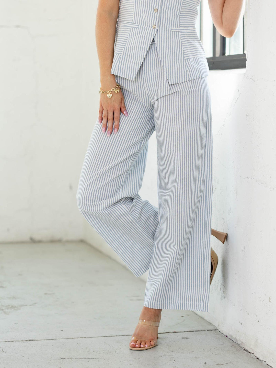 Person wearing a striped suit with wide-leg pants against a white background