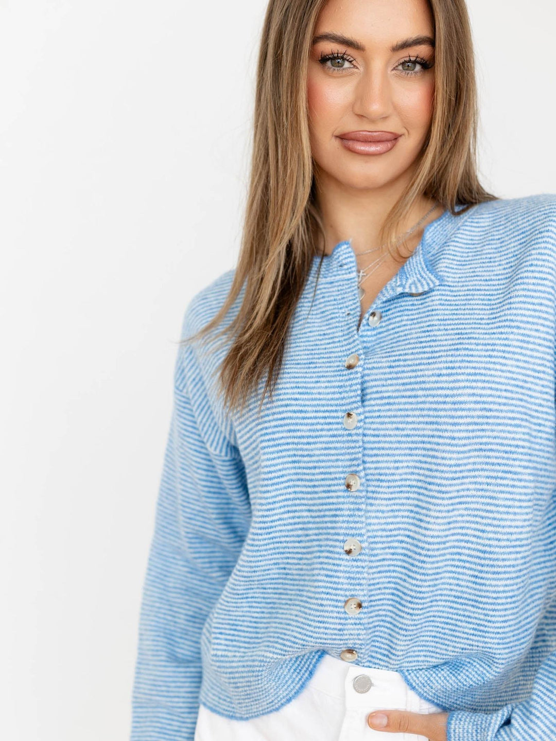 Woman wearing a blue striped shirt against a white background