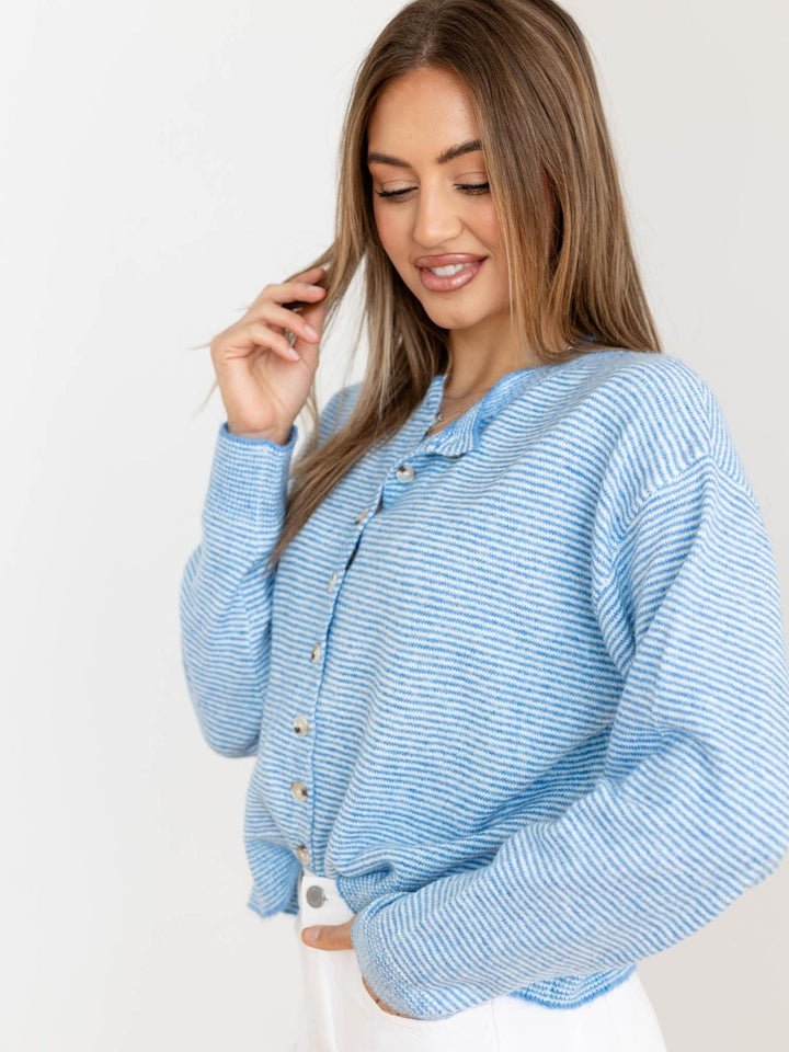 Woman wearing a blue striped shirt against a white background