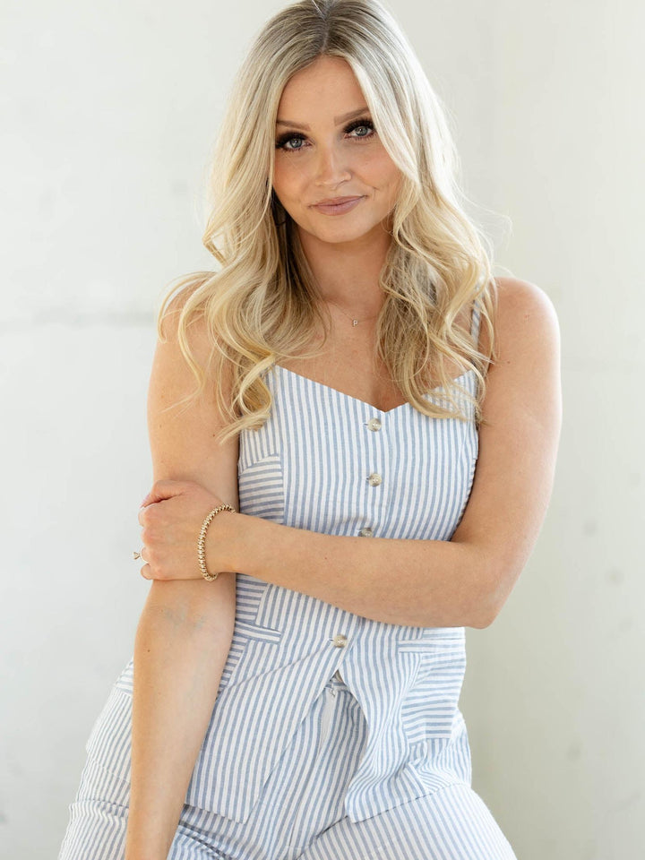 Woman wearing a light blue striped dress against a white background