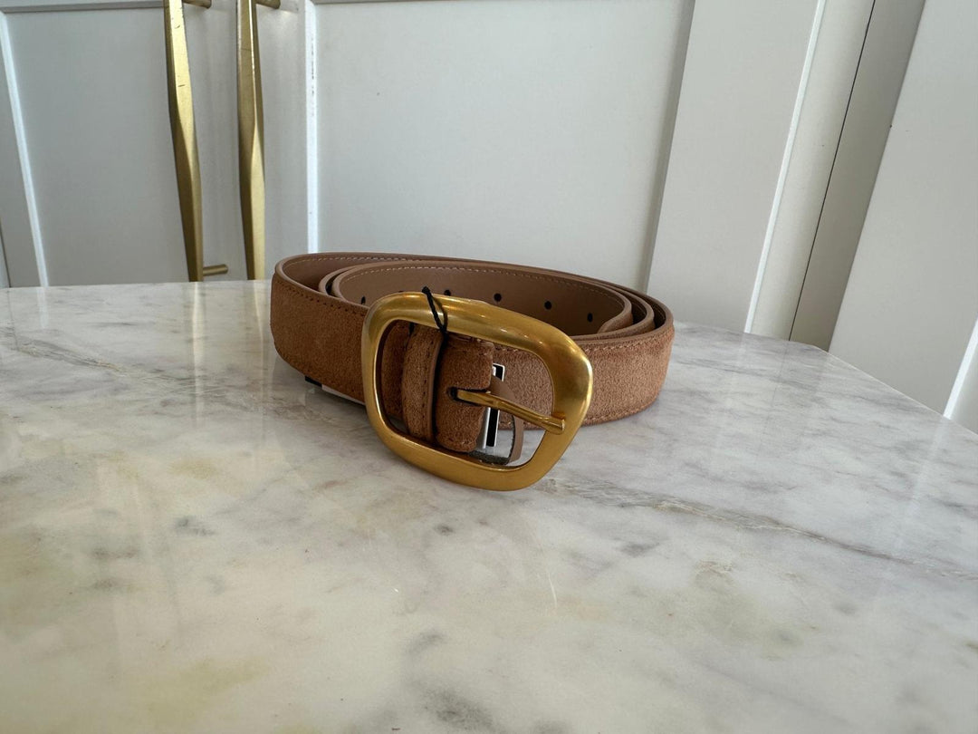 Brown belt with a gold buckle on a marble surface