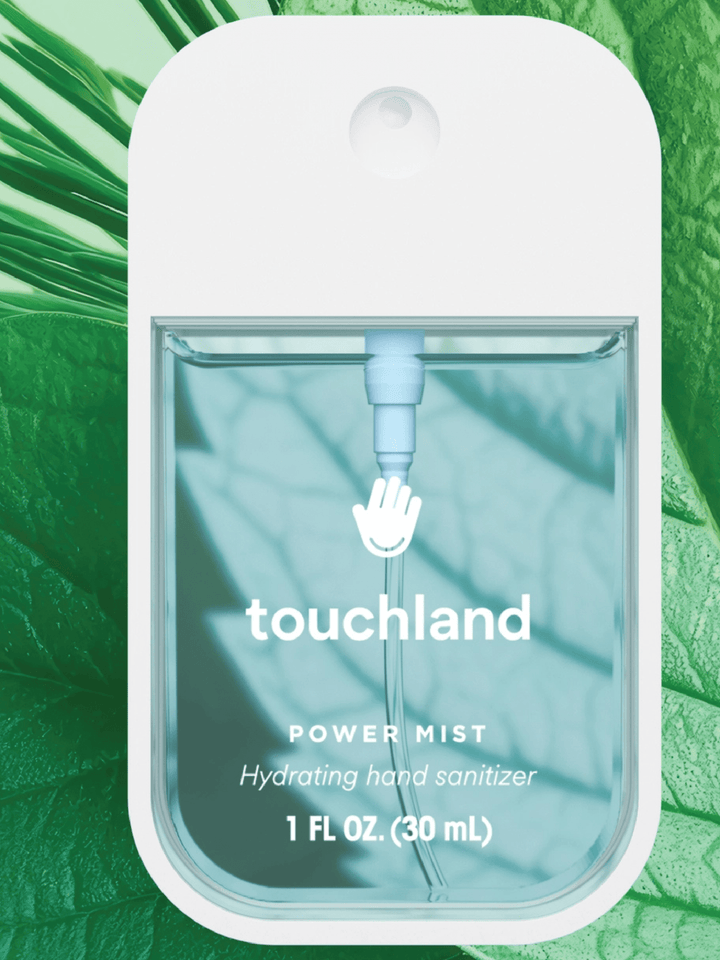 Touchland power mist hydrating hand sanitizer packaging on a green leaf background