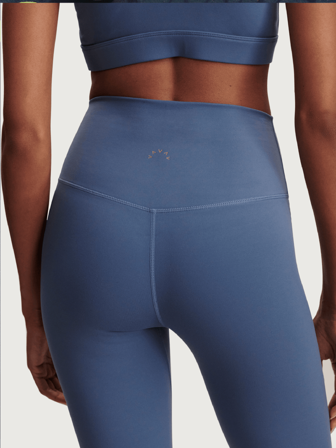 Blue athletic leggings worn by a person on a light gray background