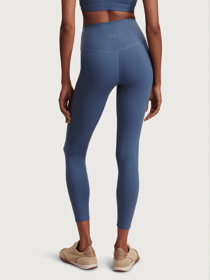 Person wearing blue leggings on a plain background