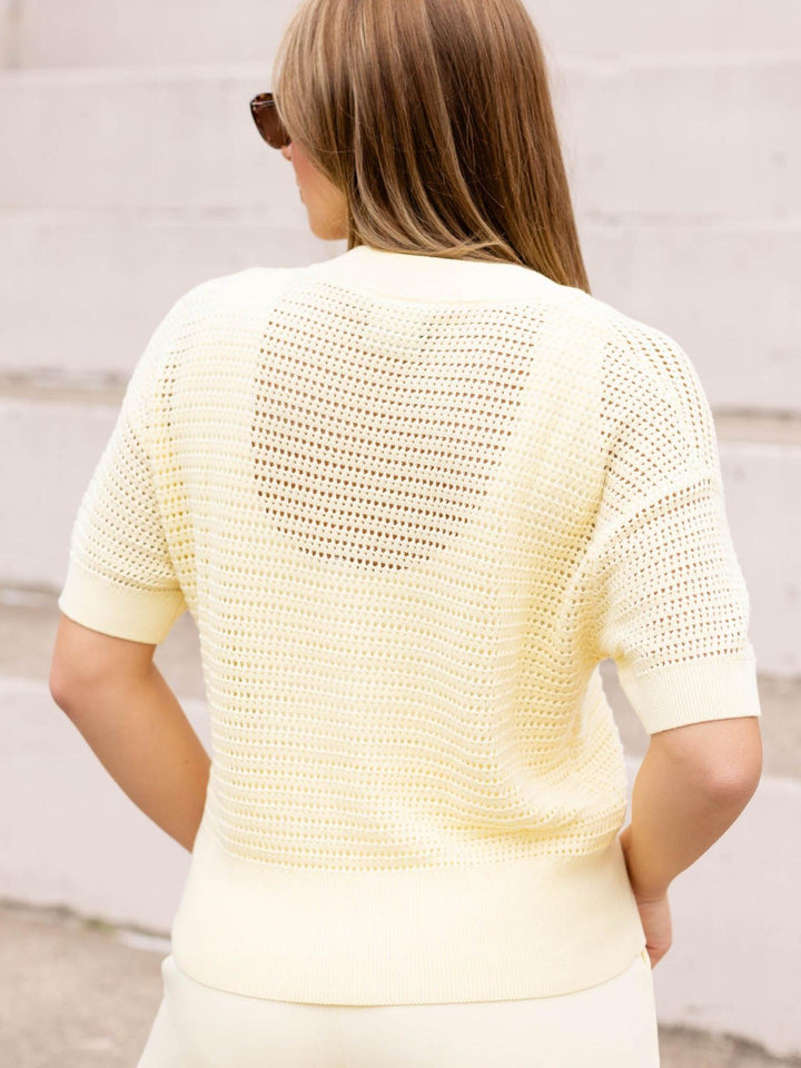 VARLEY Callie Knit Top in light yellow, featuring a breathable open-knit design and short sleeves.