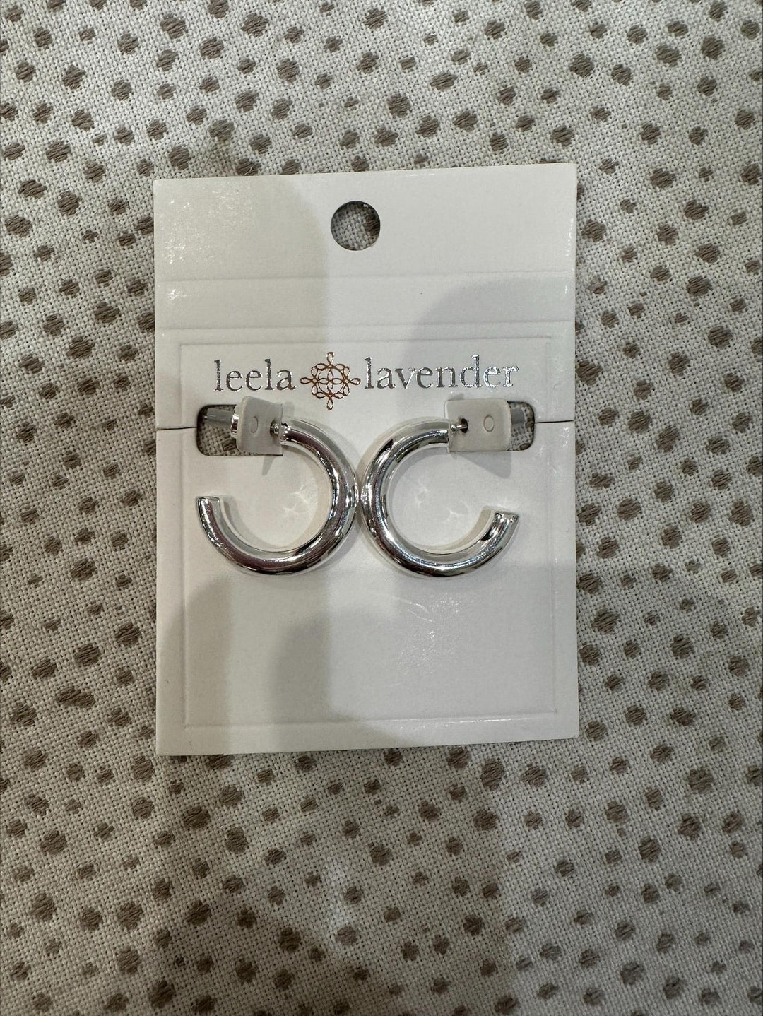 Pair of silver hoop earrings on a &