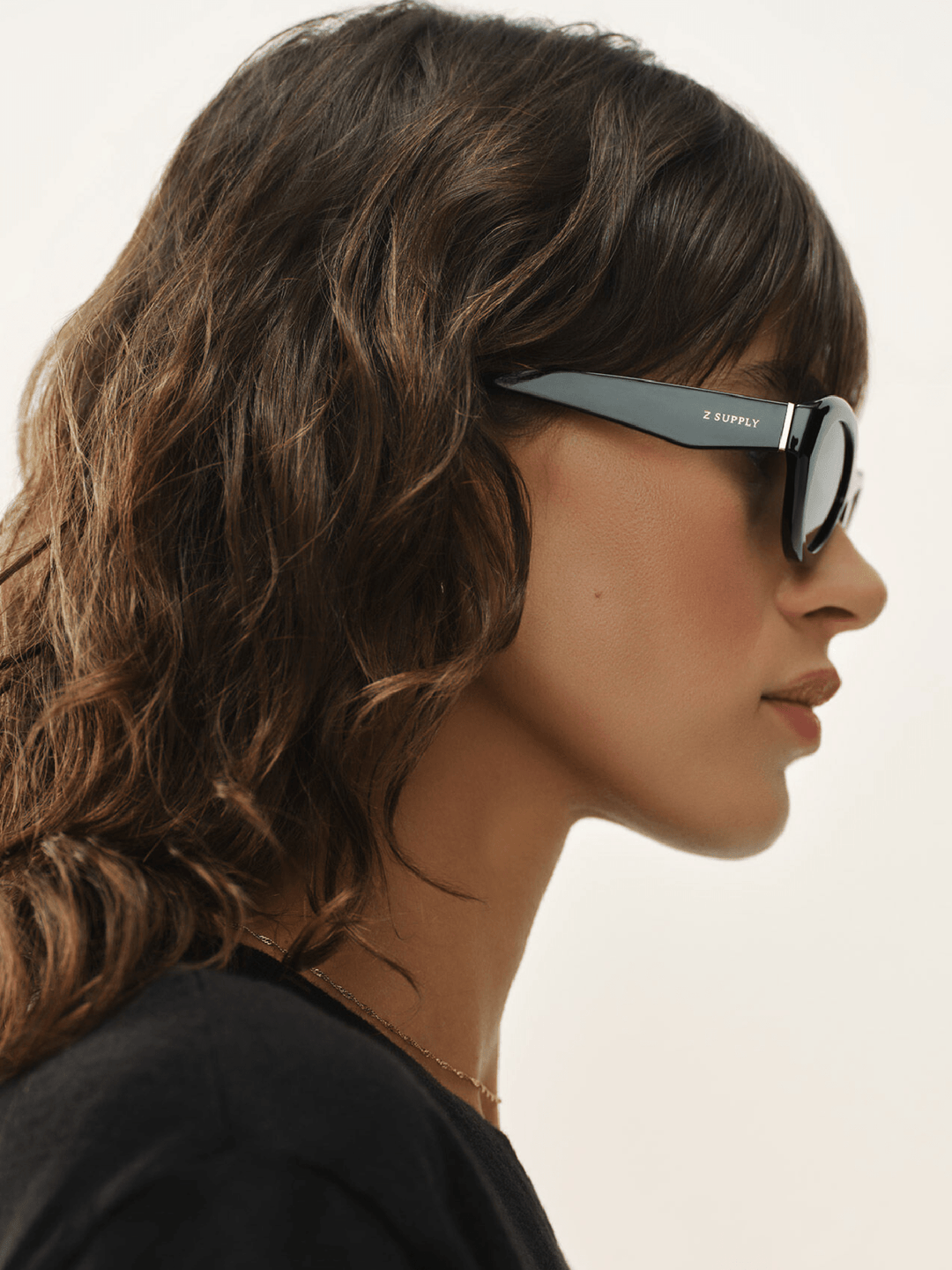 Woman wearing sunglasses with a neutral background