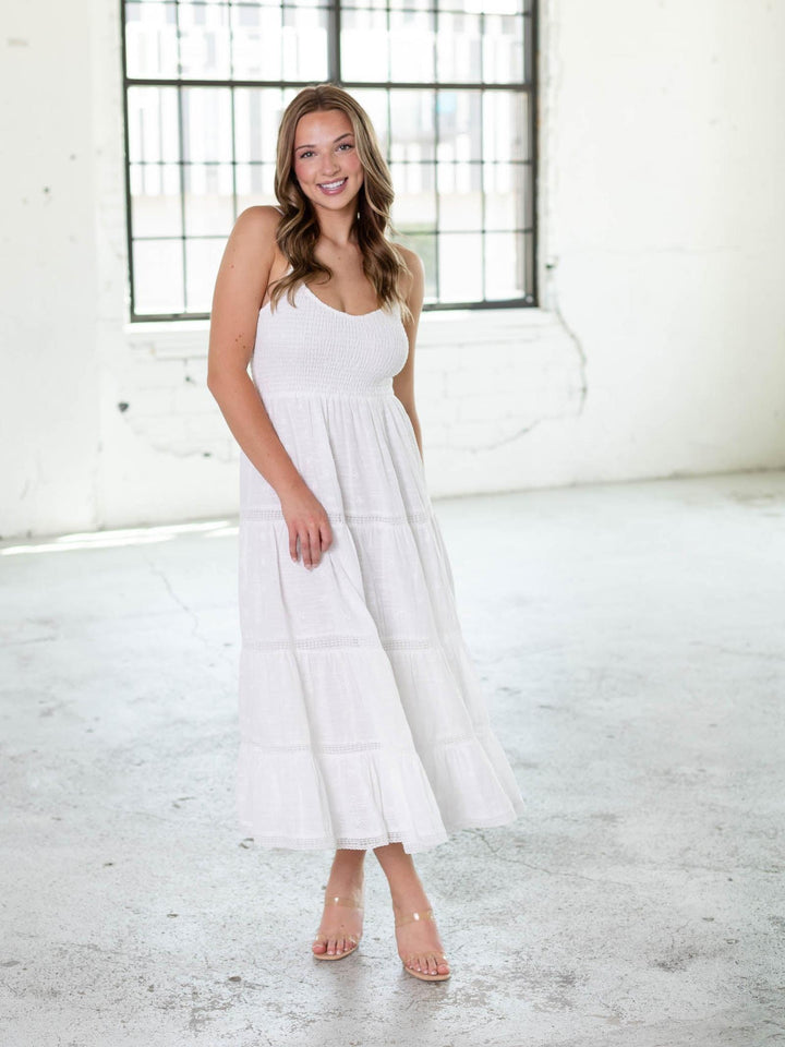 Woman in a white Z Supply Behati Eyelet Midi Dress with a smocked bodice, V-neck, and tiered skirt.