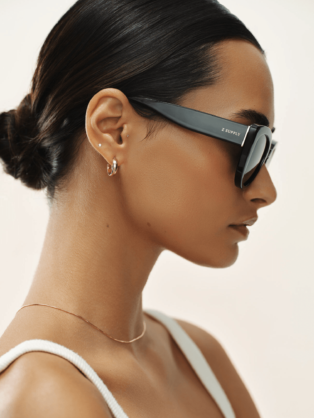 Woman wearing black sunglasses with a neutral background