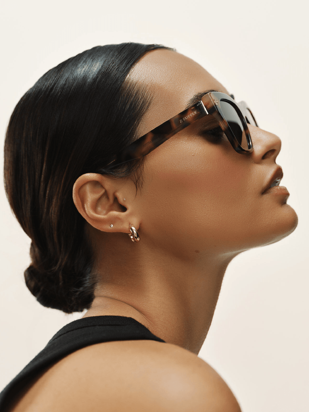 Woman wearing sunglasses with a neutral background