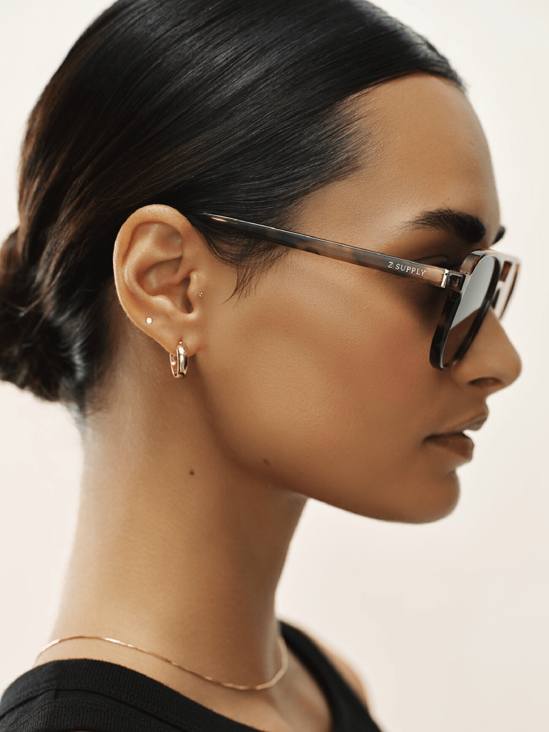Woman wearing sunglasses with a neutral background